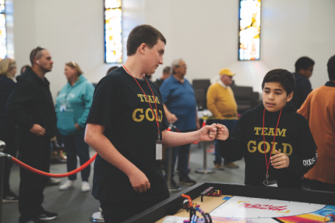 Compañeros de equipo del Team Gold de Ridgecrest Adventist Elementary se animan unos a otros antes de que comience su próxima ronda.