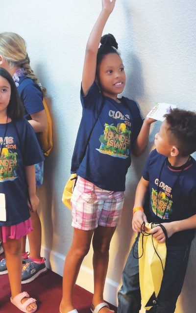 A child in Clovis raises her hand wanting to be picked to share the Bible Point.