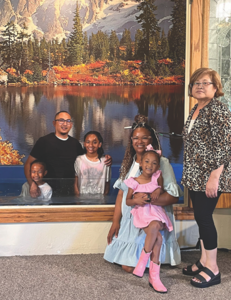 Mario Navarro, Bishop church pastor, in the baptistry pool with two of his children, who were among the 11 baptismal candidates.