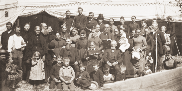 Ellen G. White, sentada detrás de los niños con la Biblia abierta y J. N. Loughborough a su derecha, en el campestre de Reno, Nevada, en 1888.