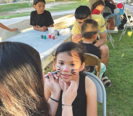 Los niños del barrio se pintan la cara durante la fiesta del Día del Niño.