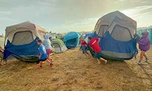 Pathfinders band together to help move tents that were in a flood zone during the storm on Tuesday afternoon