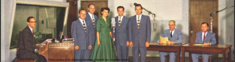The Voice of Prophecy radio group ready to go on the air in the modern studio at the headquarters in Glendale, California, adjacent to Los Angeles. From left to right: Brad Braley, Bob Seamount, Bob Edwards, Del Delker, Wayne Hooper, Jerry Dill, H.M.S. Richards, J. Orville Iverson.